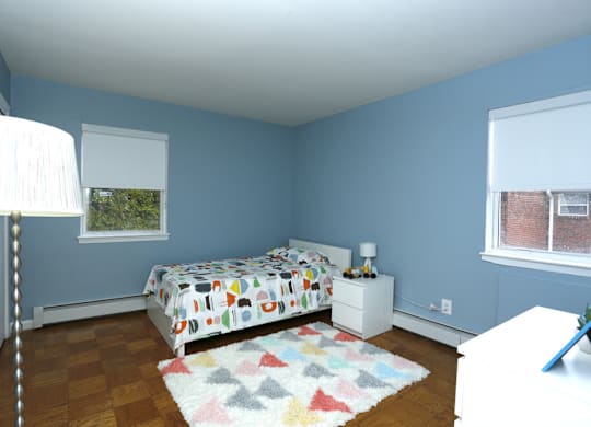 A bedroom with a bed, nightstand, and lamp.