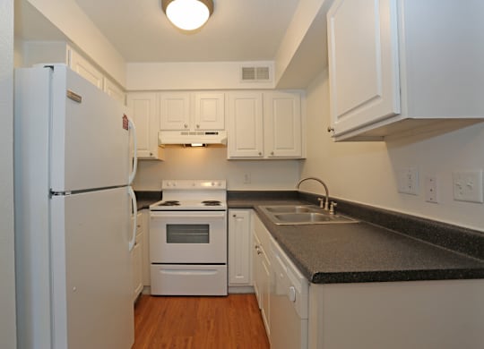 A kitchen with white appliances and cabinets.