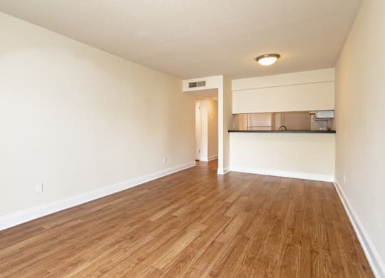 A room with wooden flooring and white walls.