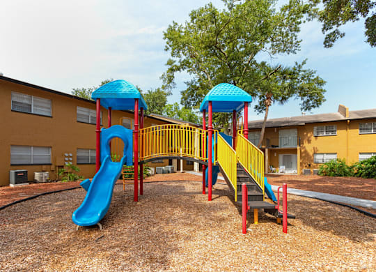 A playground with a blue slide and a yellow and red structure.