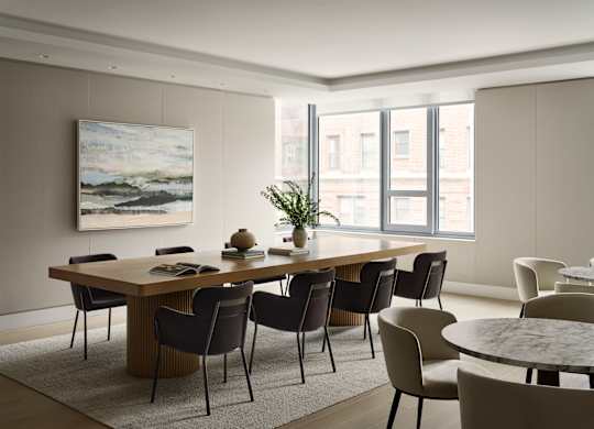 A modern dining room with a large table and chairs.