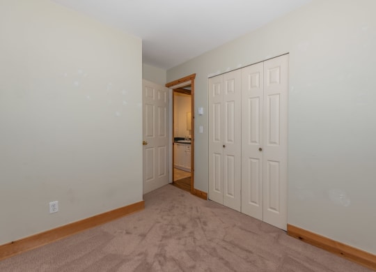 a bedroom with two closets and a door to a bathroom