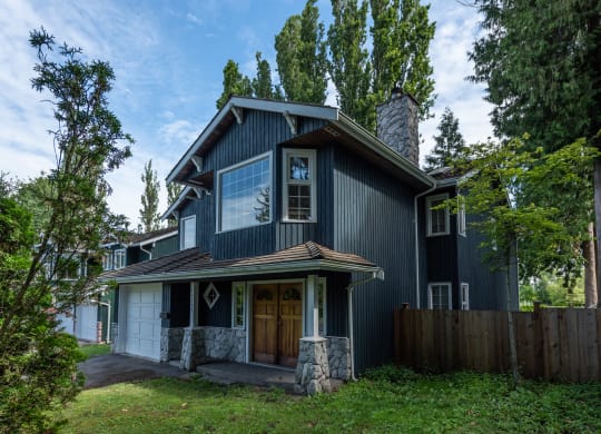 a home with a black exterior and a brown front door