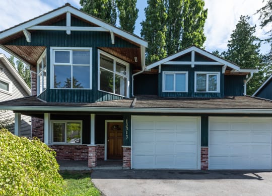 a house with a green siding and a brown roof