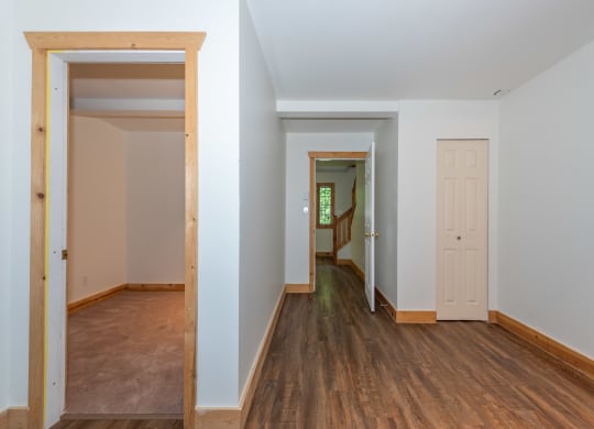 a bedroom with hardwood floors and white walls