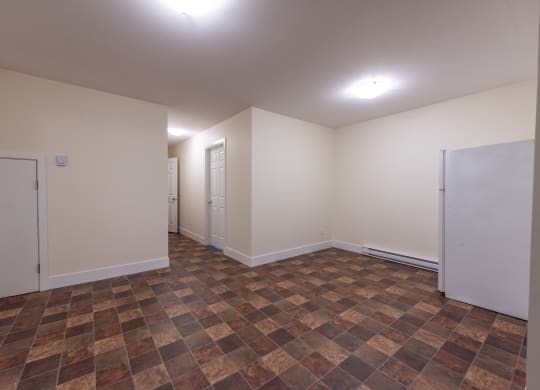 a bedroom with white walls and a tiled floor