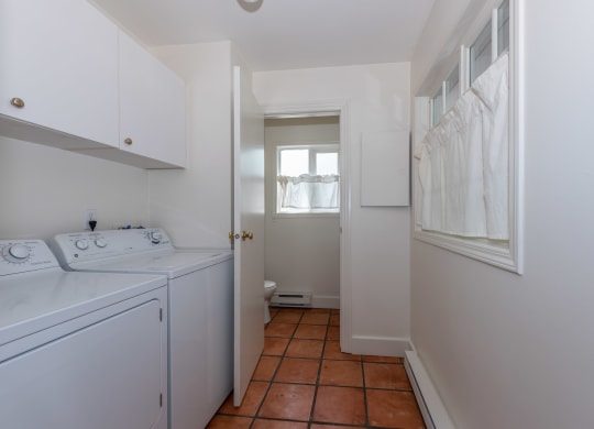 a laundry room with white cabinets and a white washer and dryer