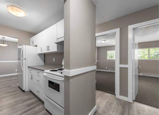 A kitchen with white appliances and cabinets.