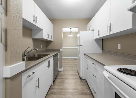 A kitchen with white cabinets and a stove top oven.