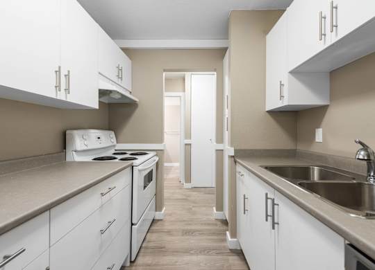 A kitchen with white cabinets and a stove top oven.