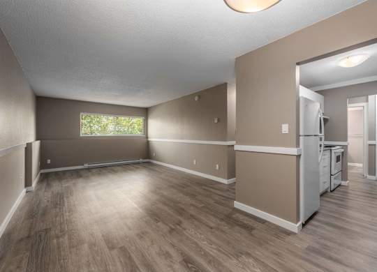 A spacious living room with a kitchen in the background.