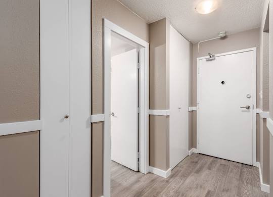 A white door is open in a room with beige walls.