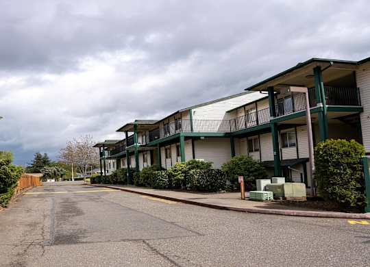 A street view of a residential area with apartment buildings on the right.