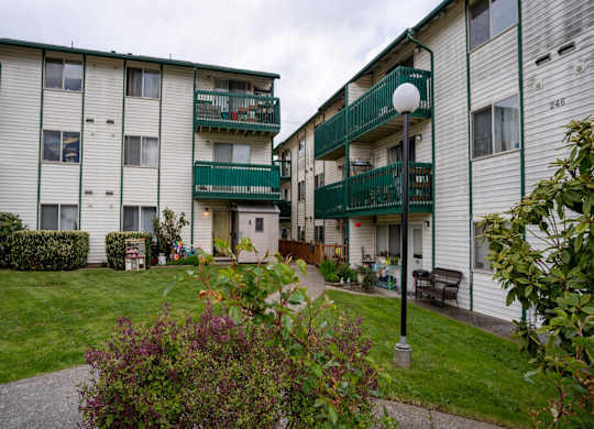 Apartment complex with green railings and white walls.