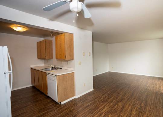 A kitchen with a white fridge and wooden cabinets.