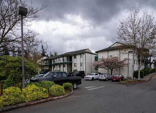 A parking lot with cars and a building in the background.