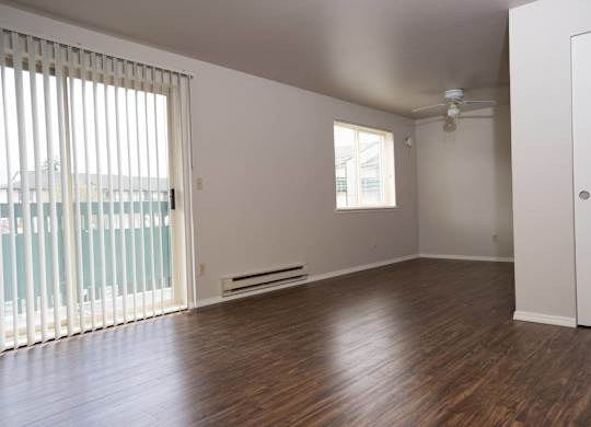 A room with wooden floors and a ceiling fan.