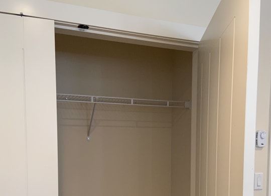a large white wardrobe with a sliding door and a hanging rail