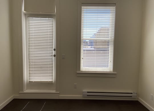 an empty room with two windows and a radiator
