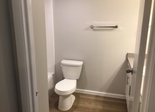 a white toilet sitting in a bathroom next to a towel rack