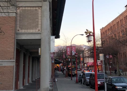 a city street with cars parked on the side of the road and a building on the right