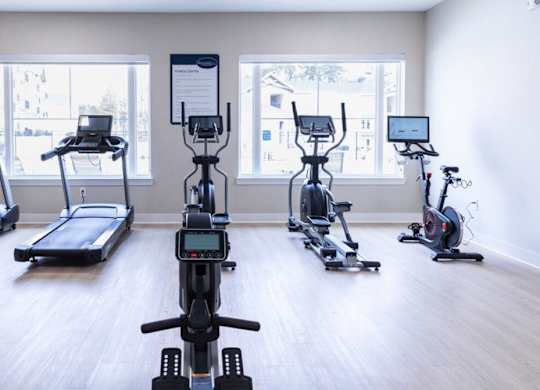 A gym with treadmills, exercise bikes, and elliptical machines.