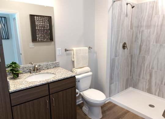 A bathroom with a toilet, sink, and shower.