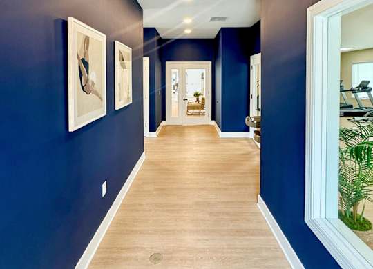 A long hallway with a blue wall and a white trim.