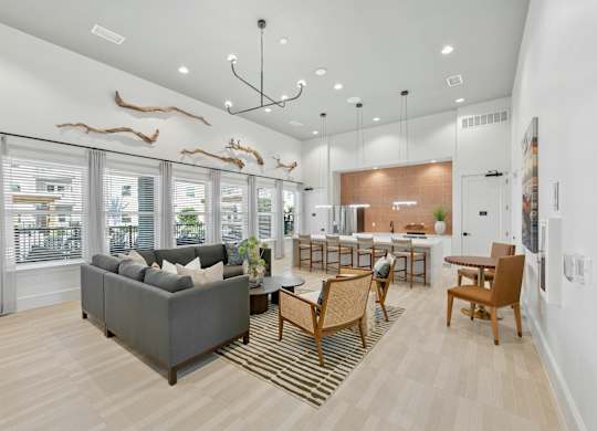 A living room with a grey couch, wooden chairs, and a rug.at Allegra at Cocoa in Cocoa, FL, 32926