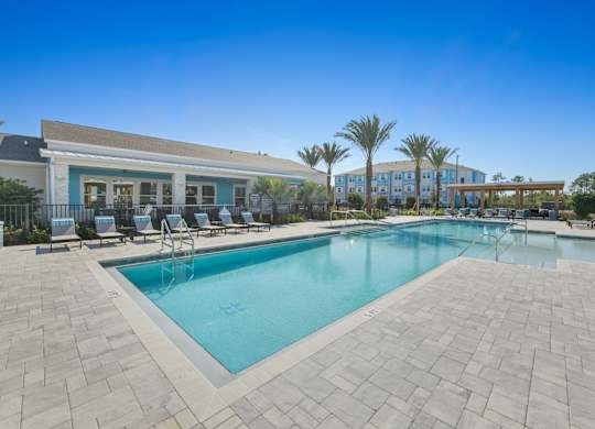 A swimming pool surrounded by a tiled patio and lounge chairs.at Allegra at Cocoa in Cocoa, FL, 32926