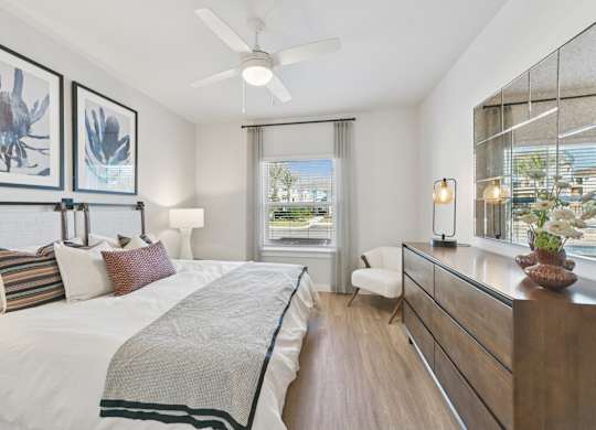 A bedroom with a large bed and a window with a view of the city.at Allegra at Cocoa in Cocoa, FL, 32926