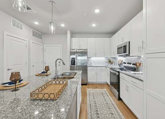 A modern kitchen with granite countertops and stainless steel appliances.at Allegra at Cocoa in Cocoa, FL, 32926