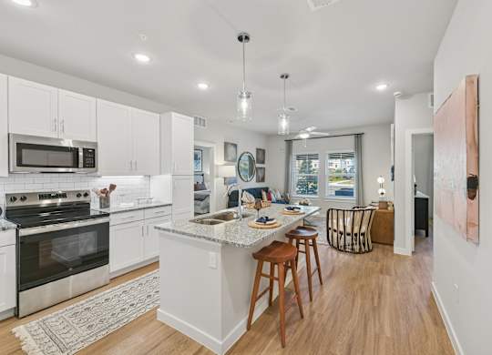 A kitchen with white cabinets and a large island.at Allegra at Cocoa in Cocoa, FL, 32926