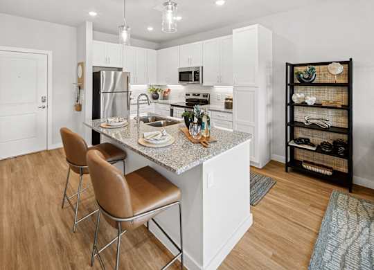 A kitchen with a granite countertop and white cabinets. at Allegra at Cocoa in Cocoa, FL, 32926