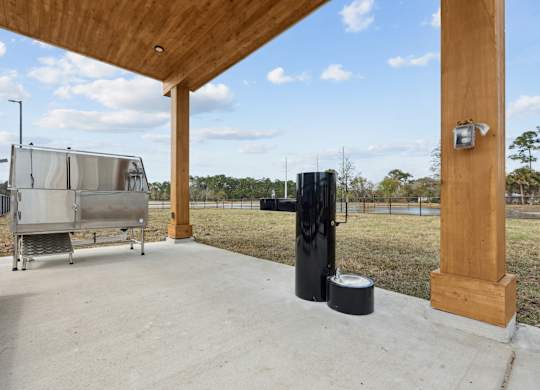 A black drinking fountain for people and pets next to a pet bath at Allegra at Cocoa in Cocoa, FL, 32926