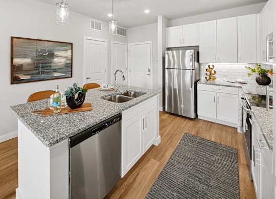 A kitchen with a granite countertop and stainless steel appliances. at Allegra at Cocoa in Cocoa, FL, 32926