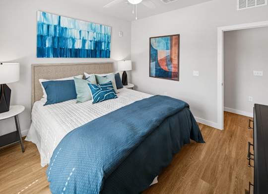 A bedroom with a large bed and a painting on the wall. at Allegra at Cocoa in Cocoa, FL, 32926