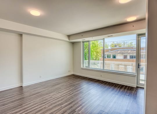 the living room of an empty apartment with a large window