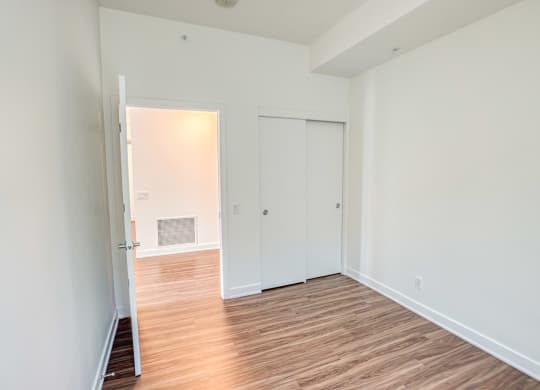 an empty room with wood flooring and white walls