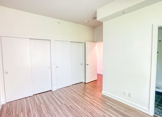 an empty living room with white walls and wood flooring