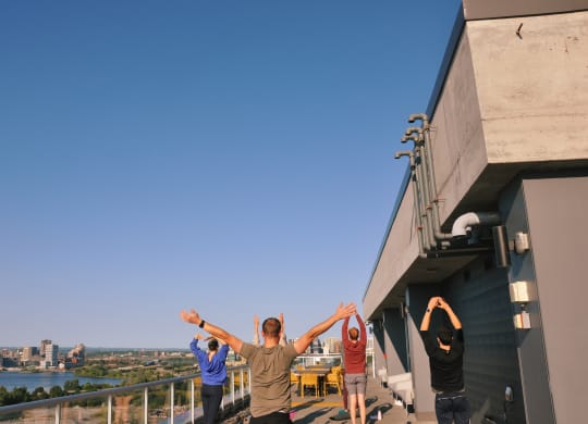 a group of people standing on the top of a building with their hands up