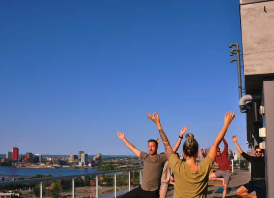a group of people on a balcony with their hands up in the air