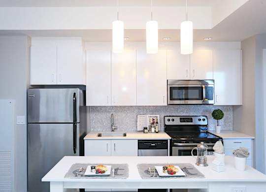 a white kitchen with stainless steel appliances and white cabinets