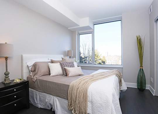 a bedroom with a bed and a large window