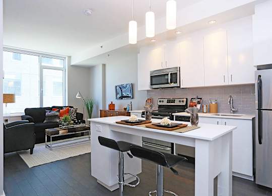 a kitchen with a white island and a stainless steel refrigerator