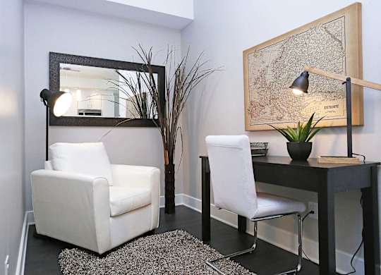 a living room with two white chairs and a desk with a mirror