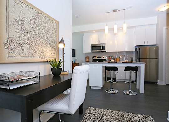 a kitchen and dining room with white cabinets and stainless steel appliances