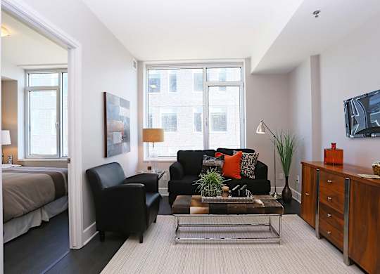 a living room with a couch and a table in front of a window