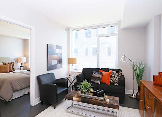 a living room with a couch and a table and a bedroom
