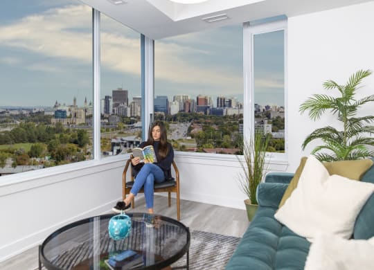 a woman sitting in a chair in a living room with a view of the city